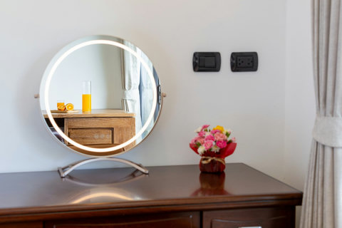 Dressing table with lit vanity mirror and fresh flowers at Villa Yoco, Koh Samui