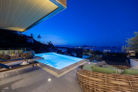 Illuminated infinity pool and terrace at dusk overlooking the coastline at Villa Yoco, Koh Samui