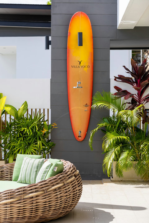 Villa exterior with branded surfboard and tropical garden at Villa Yoco, Koh Samui