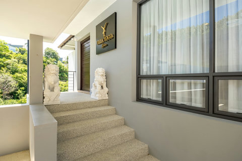 Villa entrance with staircase and traditional guardian statues at Villa Yoco, Koh Samui