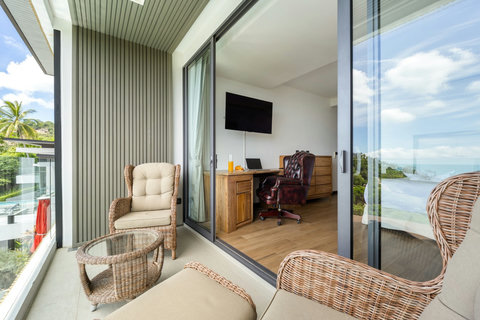 Bedroom with recliner, work desk and sea-view balcony at Villa Yoco, Koh Samui