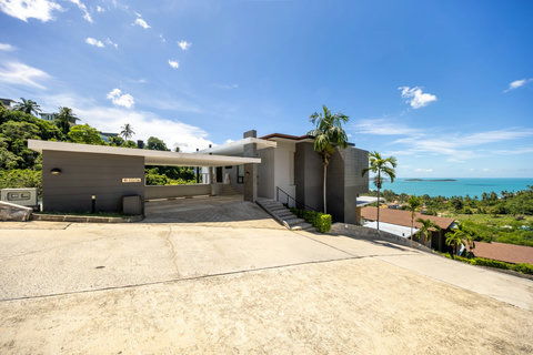 Contemporary villa exterior with driveway, tropical garden and sea views at Villa Yoco, Koh Samui