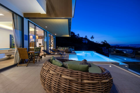 Illuminated villa and infinity pool at dusk overlooking the coastline at Villa Yoco, Koh Samui