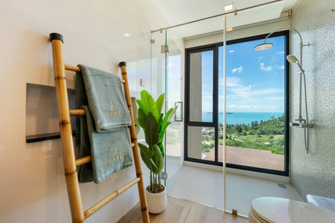 Walk-in shower with bamboo towel ladder, plant and sea views at Villa Yoco, Koh Samui