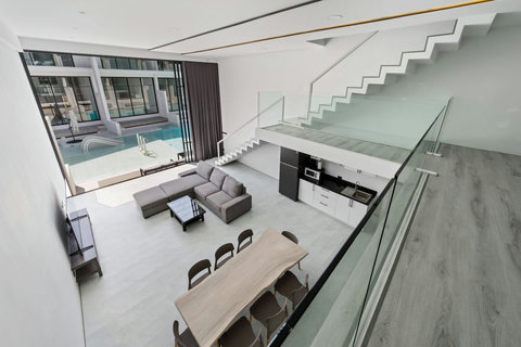 Open-plan living room with modern staircase at C'est la Vie, Replay Residence Koh Samui