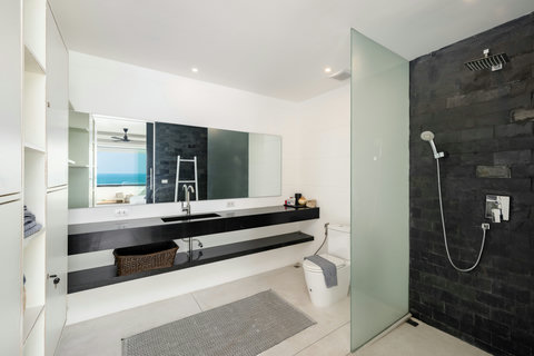 Contemporary bathroom with dark stone vanity and rain shower in Koh Samui oceanview villa