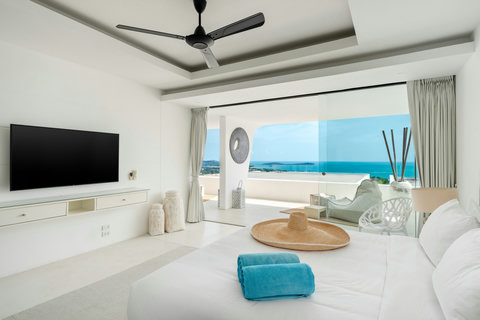 Oceanfront lounge terrace with plush seating and wicker table at luxury Koh Samui villa rental
