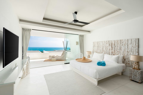 Comfortable bedroom with turquoise accents and ambient lighting at Villa Ocean Serenity Thailand