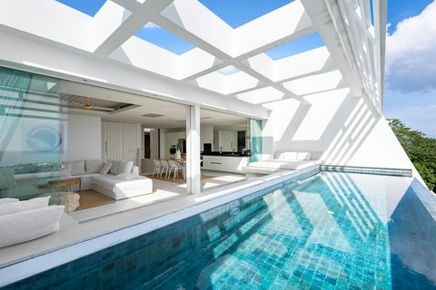 Open-plan living area with floor-to-ceiling glass walls and ocean views in luxury Koh Samui villa