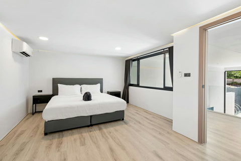Stylish en-suite bathroom with contemporary lighting and rain shower at this Samui condo