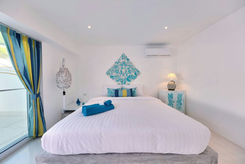 Serene master bedroom with turquoise accents and tropical views Samui
