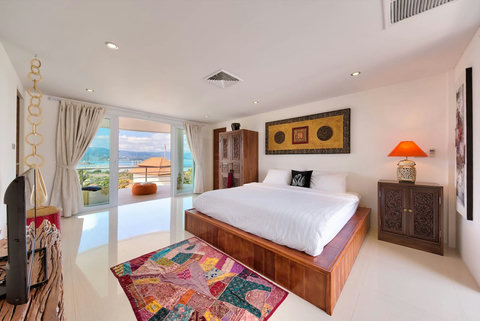 Master bedroom with colorful Thai textiles and ocean views Koh Samui