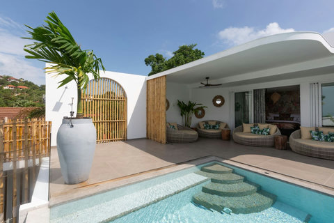 Landscaped pool area with stone features and tropical garden at C Villa, Koh Samui Thailand