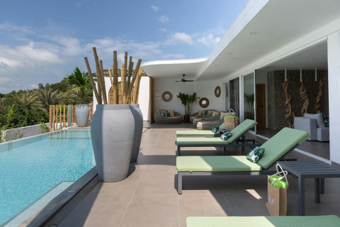 Poolside deck with sun loungers and umbrella at C Villa 8-bedroom retreat, Koh Samui