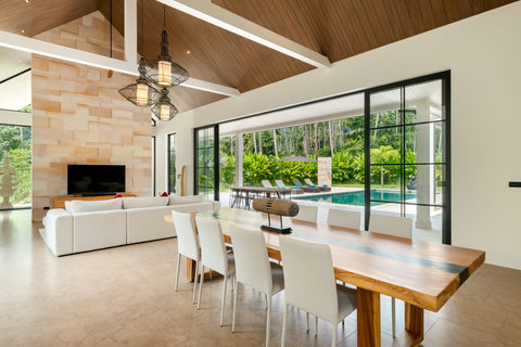 Settle into wood warmth. Your bed frames views of the main living area and terrace beyond, blending privacy with openness.