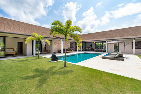 Step onto manicured green lawn, dive into your private pool, and retreat under the covered terrace as palms frame the entire scene.