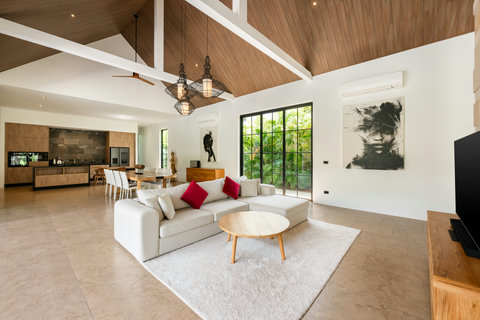 Breathe in height and light. Soaring timber beams frame curated artwork while glass doors connect you to the garden beyond.