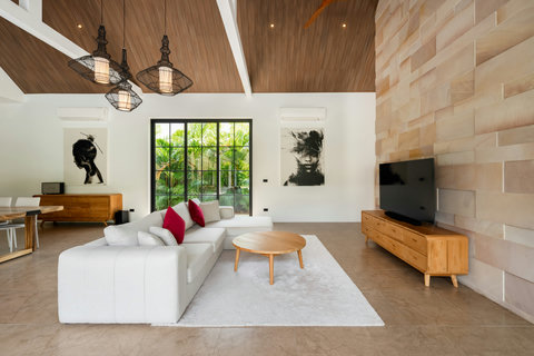 Gather here. This luminous living room blends modern comfort with natural wood warmth, perfect for evening conversations or quiet afternoons.