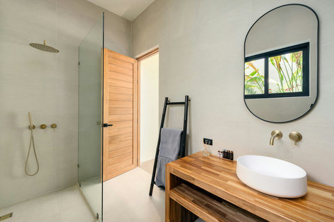 A serene rinse. Timber accents and soft curves create a resort-like bathroom that feels both modern and warm.