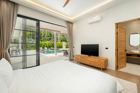 Wake to water views. Slide open the glass doors and step straight onto the pool terrace from this serene, light-filled bedroom.