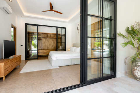 Wake to garden light through full-width glass doors, slip straight out to the pool, and fall asleep under the gentle spin of the overhead fan.
