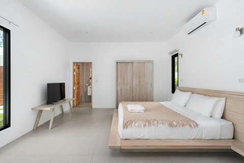 Luxurious bedroom with direct pool access and tropical views