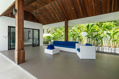 Covered poolside lounge with tropical garden backdrop