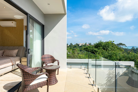 Private balcony with rattan seating and panoramic sea views at Villa Gala, Chaweng Noi