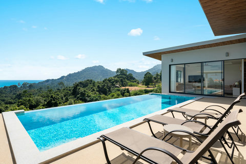 Spacious infinity pool with panoramic ocean views and sun loungers — perfect for relaxing under the Samui sun.