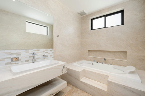 Bright ensuite bathroom featuring a soaking tub and modern stone finishes — pure relaxation at Villa Gala, Chaweng Noi.