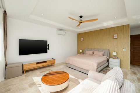 Stylish guest suite featuring a cozy lounge area, king bed, and ocean-facing windows — relaxation with a view at Villa Gala.