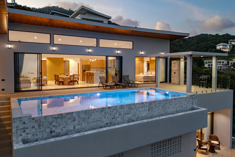 Modern hillside design with infinity pool and glowing evening ambiance — luxury living at Villa Gala, Chaweng Noi.