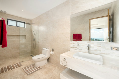 Contemporary ensuite with walk-in rain shower and natural tones for a spa-like experience.