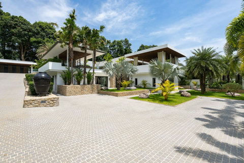 Multi-level villa pavilions with covered walkways and balconies amid tropical gardens