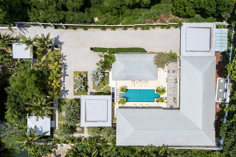 Bird's eye view highlighting the villa compound layout with pool and lush surroundings