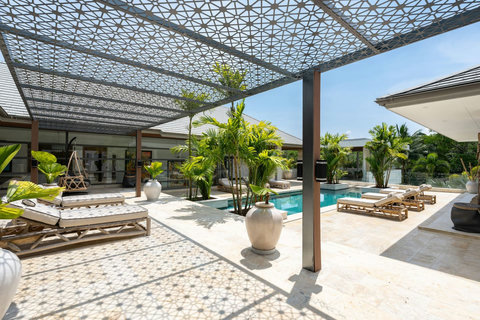 Sun-drenched courtyard with pool deck, loungers, and traditional stone accents