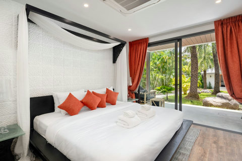 Charming twin bedroom with colorful accents, red curtains, and tropical garden views