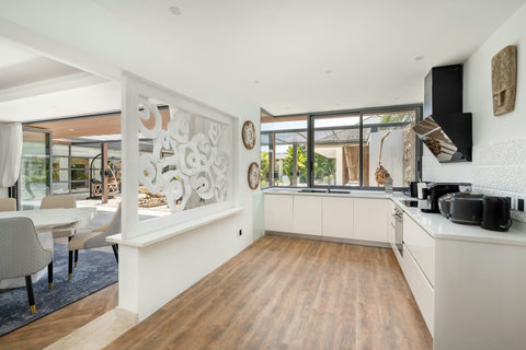 Modern fully equipped kitchen with island counter and seamless indoor-outdoor flow