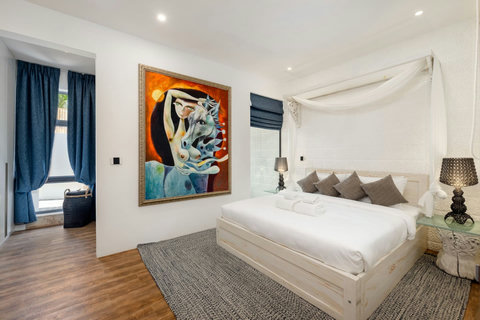 Luxurious master bedroom with king-size bed, contemporary art, and elegant lighting