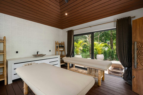 Cozy bedroom with dark timber ceiling, crisp white bedding, and warm ambient lighting