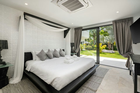 Serene bedroom with romantic canopy draping, air conditioning, and tranquil atmosphere
