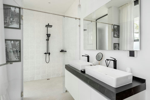 Sleek modern bathroom with freestanding bathtub, rain shower, and black designer fixtures