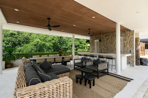 Al fresco lounge area with plush black seating nestled in tropical surroundings