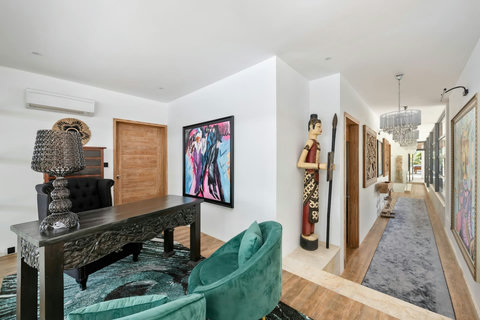 Stylish hallway gallery adorned with original artwork leading to the private bedrooms