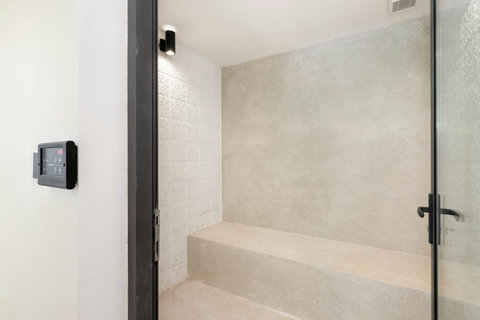 Tropical open-air outdoor shower surrounded by natural stone and lush greenery