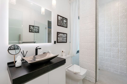 Sophisticated bedroom featuring a sleek dark accent wall and designer furnishings