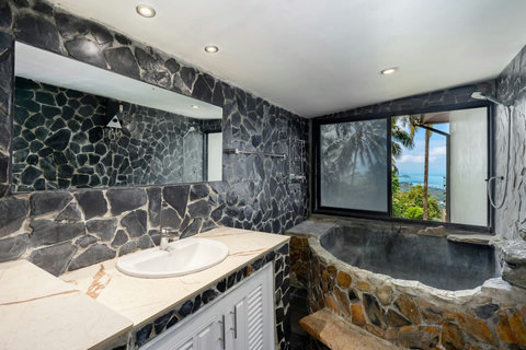 Elegant interior with natural stone and lush greenery at Moonview Paradise Village Koh Samui