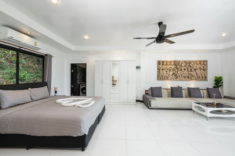 Luxurious master bedroom with king bed and ceiling fan at Moonview Paradise Village Koh Samui
