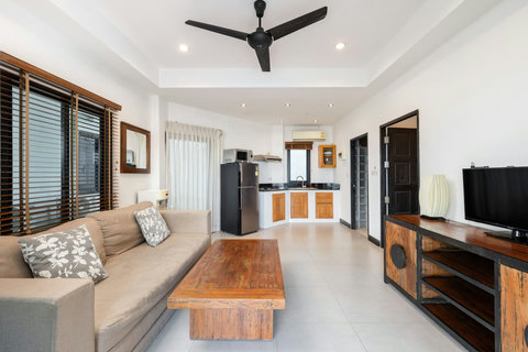 Bright bedroom with wooden shuttered doors and panoramic sea views at Sunview Paradise Village Koh Samui