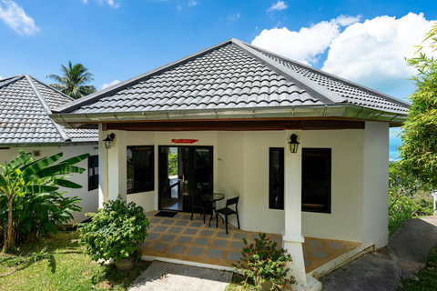 Charming Koh Samui bungalow exterior with peaked roof and lush tropical landscaping